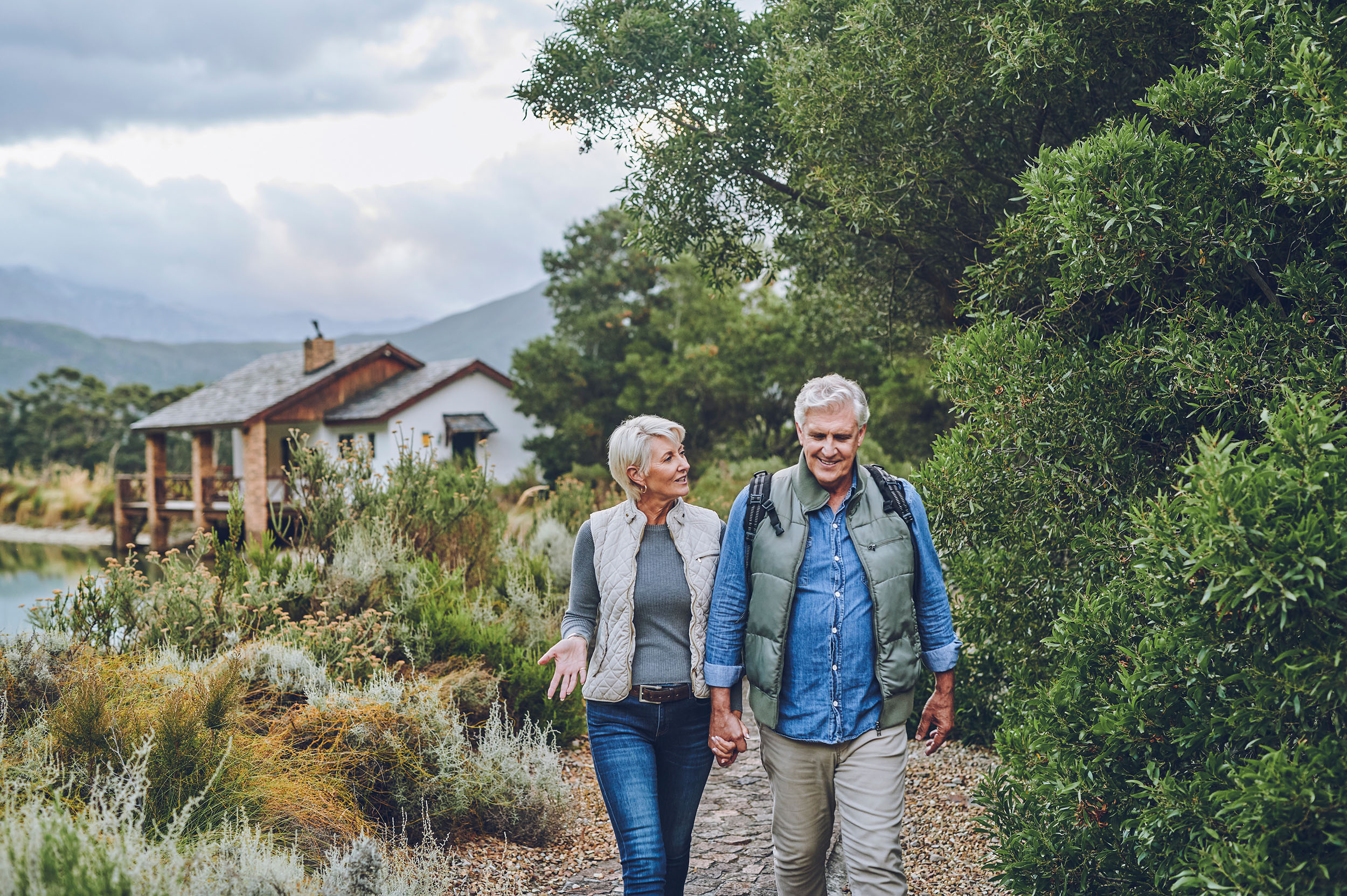 Senior couple hiking in nature in countryside, walking in park on international vacation and communication during exercise walk on adventure in retirement. Happy, smile and elderly couple.